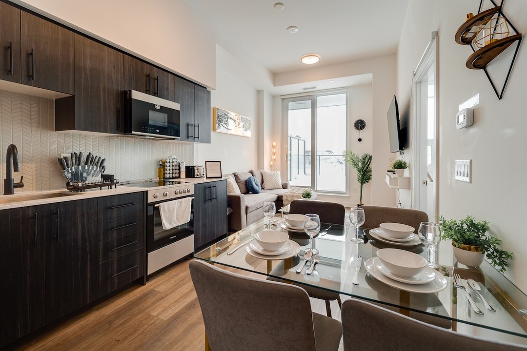Airbnb dynamic catalog ad showing an interior listing photo of an open-plan kitchen, dining table and living room in a rental home